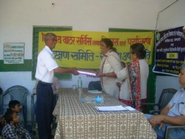 A certificate being handed over beneath the programme banner.