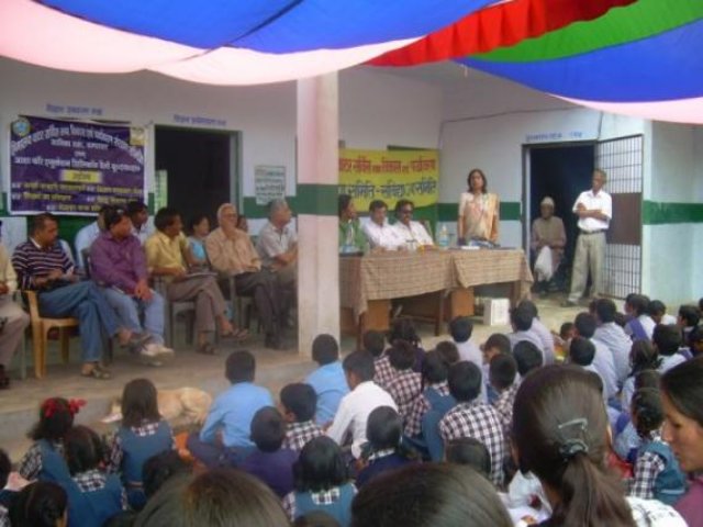 A gathering in a room hung with bunting, children seated at the front.
