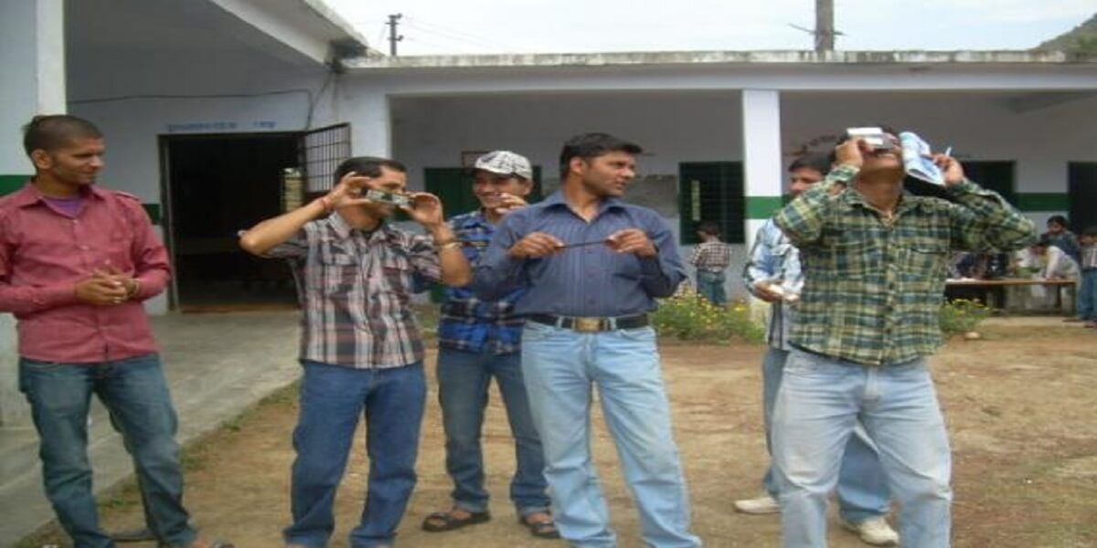 Men in the yard trying out hand-held instruments.