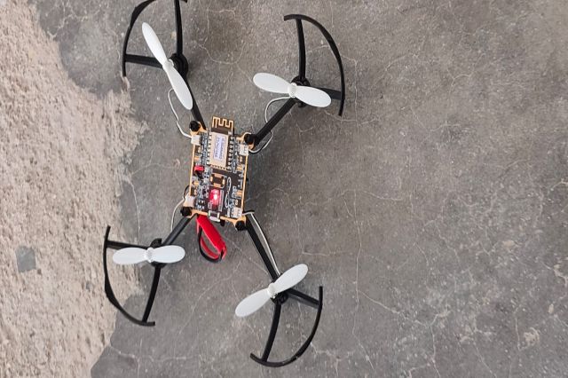 A small quadcopter built during a workshop, resting on the ground.