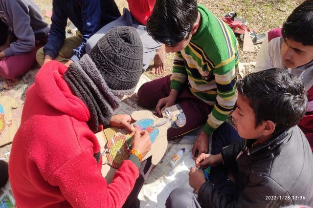 Children gathered round during a village session in cold weather.