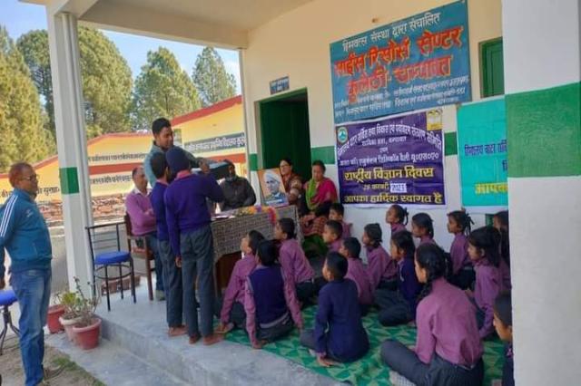 Children seated on the floor for a National Science Day demonstration at Kulethi.