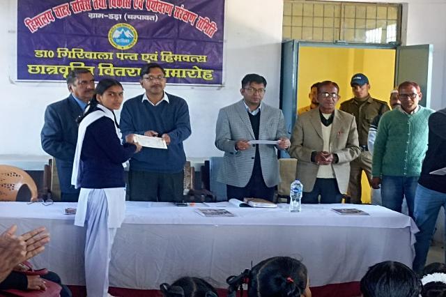 A student receiving a scholarship certificate on stage.