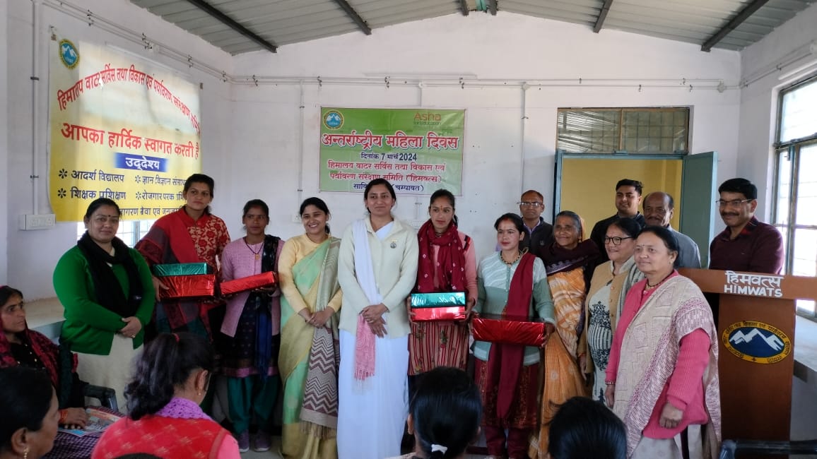 Women lined up with their certificates in front of the programme banner.