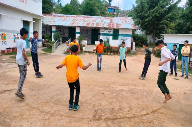 Children playing a game in the yard during the June 2024 summer camp.