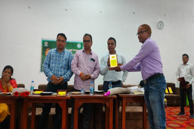 A memento being presented across the table at the World Bee Day programme.