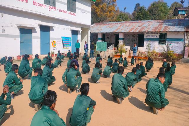 Students seated in rows in the school courtyard for a World Glaucoma Week session.